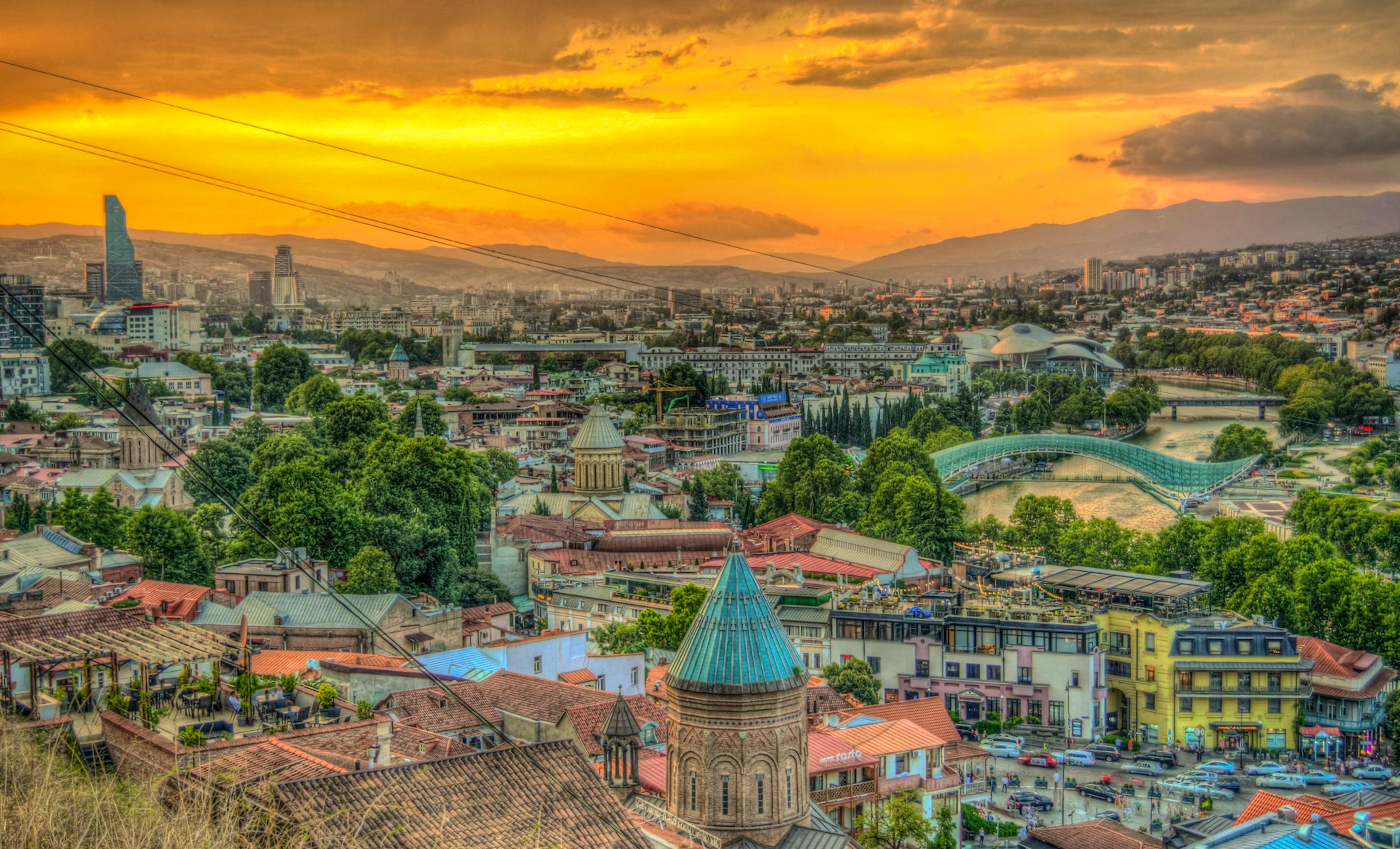 Stunning panoramic view of Tbilisi at sunset with golden skies and colorful architecture